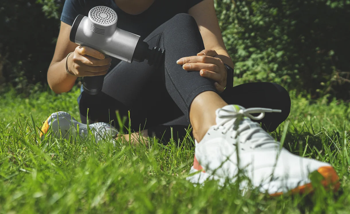 A woman sitting on the grass with a hair dryer.